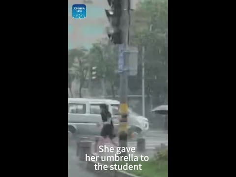 Driver hands an umbrella to a student in heavy rain